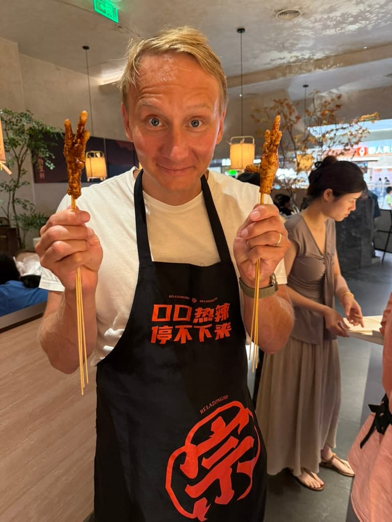 Sami trying chicken skewers at Nanchang restaurant